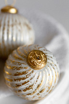Close Up of Gold and White Christmas Ornaments on a White Background