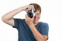 Smiling man holding a camera.