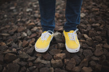 yellow sneakers standing on the gravel
