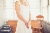 torso of a bride standing in a wedding dress