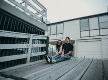 couple sitting on a wooden ramp 