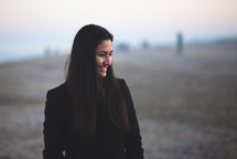 Portrait of a young woman at the beach with winter clothing. Lifestyle photography