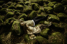 Couple laying on moss covered rocks