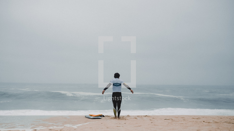 a surfer standing on a beach 