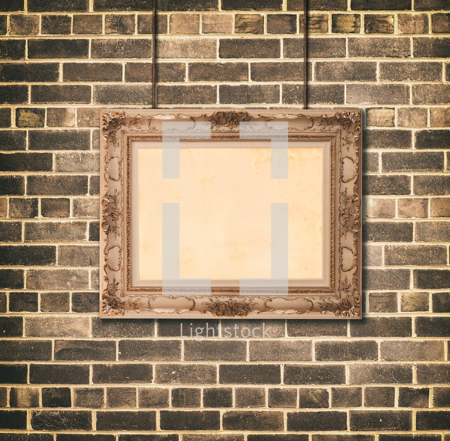 Golden picture frame on brick wall background. Vintage baroque style object