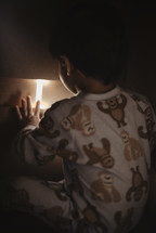 a toddler boy in pajamas and a nightlight 