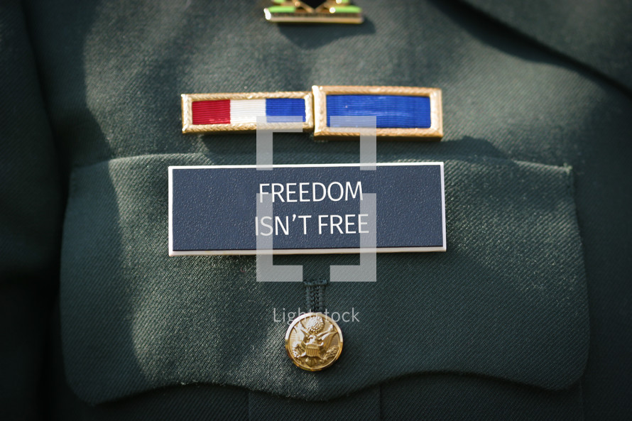 Freedom isn't free printed on the military name badge of uniform. 