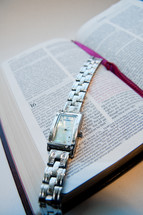 watch lying over the pages of a Bible