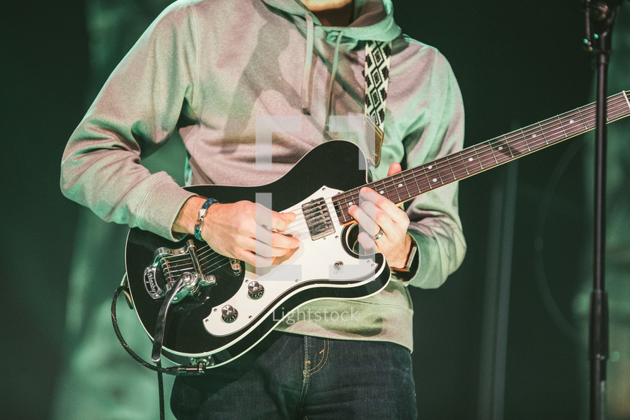 a man playing a guitar on stage 