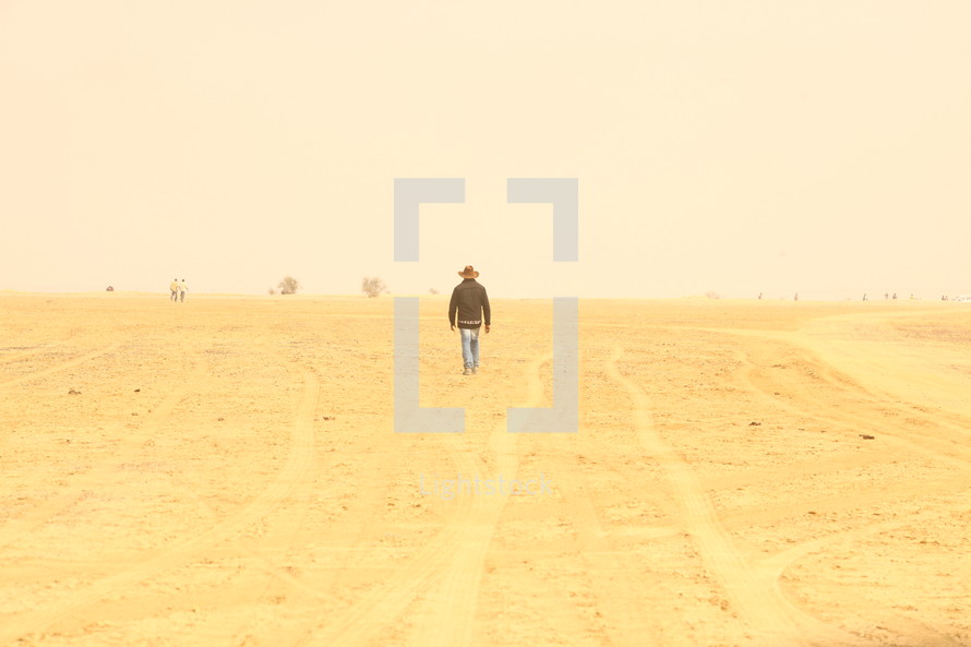 man walking through the desert 