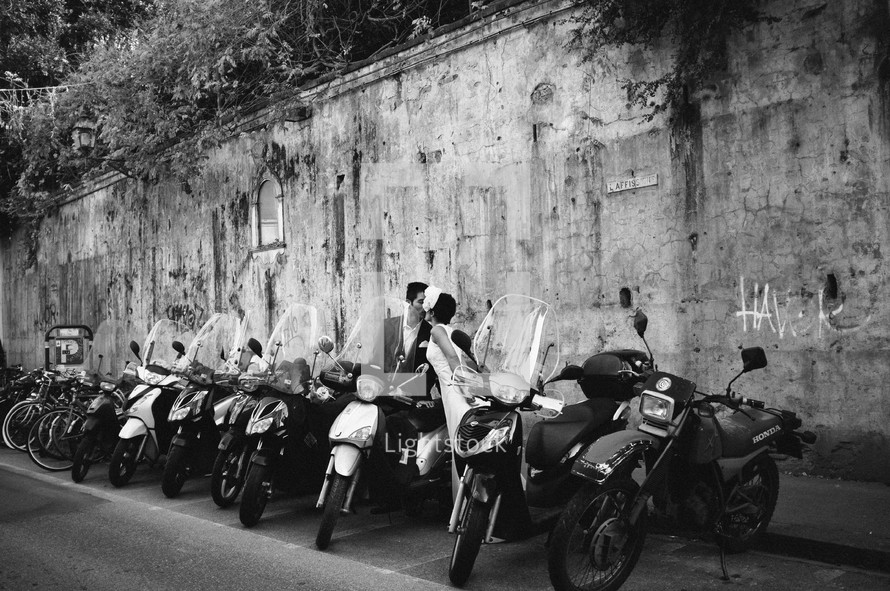 Couple kissing besides mopeds