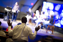 man with his hands raised in worship to God during a worship service 