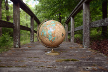 a globe on a weathered wood boardwalk 