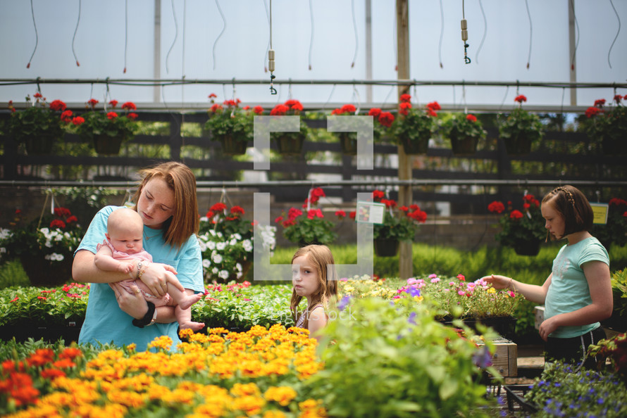 sisters picking out flowers at a garden center 