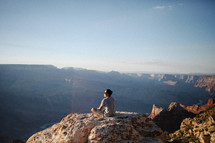 man sitting on a mountaintop 