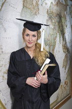 college student standing in her cap and gown at graduation 