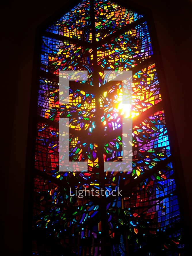 Stained glass window to Heaven with blue, red, yellow, purple colors in a small church chapel.