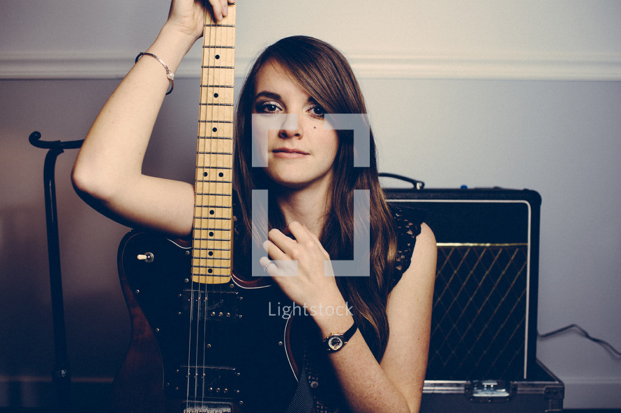 woman holding an electric guitar 