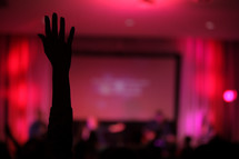 silhouettes, projection screen, congregation, parishioners, standing, raised hands, worship service 