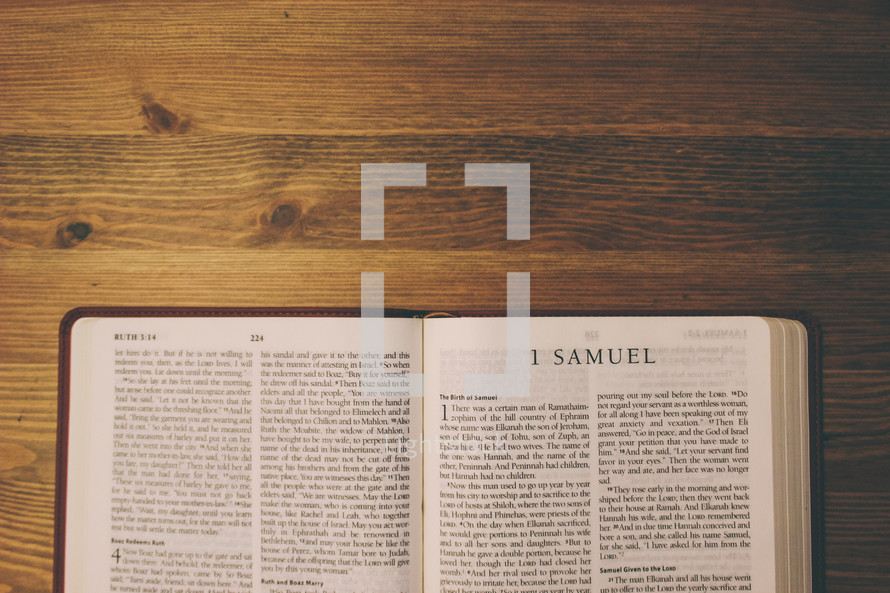 Bible on a wooden table open to the book of 1 Samuel.