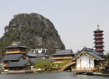 Chinese houses beside water - rock hill behind