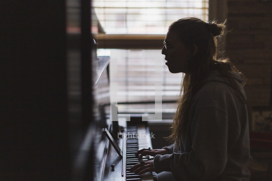 a girl playing a piano and singing 