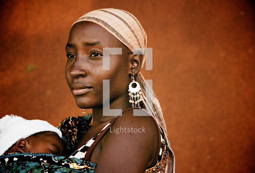 young African woman holding an infant 