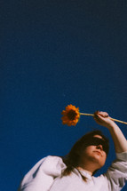a young woman holding a sunflower 