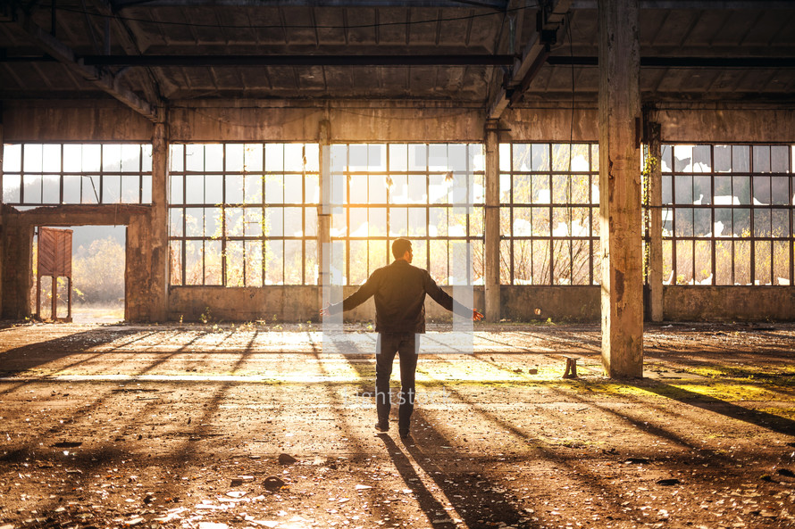 a man standing in an old empty warehouse building 