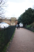 couple walking under a bridge 