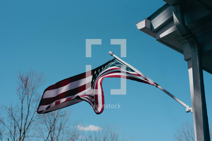 American flag on a flagpole with blue sky in the background.