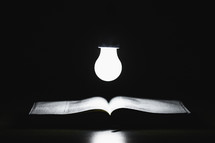 a lightbulb over an open Bible 