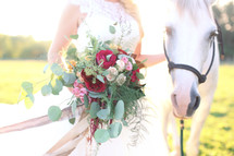 bride with a horse holding a bouquet 