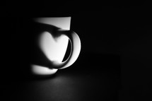 Abstract heart shadow in handle of cup of coffee
