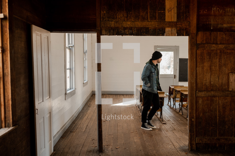 man walking through an old schoolhouse 