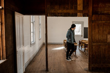 man walking through an old schoolhouse 