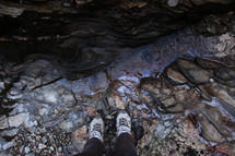 Feet standing on colorful rocks.