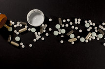 Various drugs and pills spilling from a bottle
