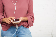 a woman listening to a cellphone with earbuds 