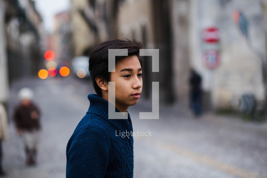 teen boy crossing a street 