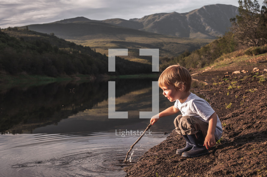 toddler playing in a lake 