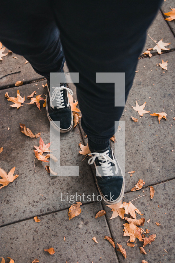 woman standing on a sidewalk in fall 