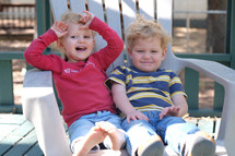 toddlers in a chair outdoors 