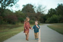brother and sister walking holding hands 