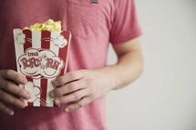 man holding a box of popcorn 