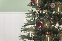 Festive Christmas Tree Closeup: Ornaments, Lights, and Beadboard Elegance