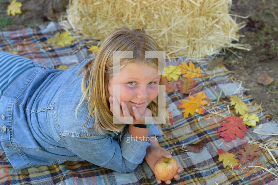 smiling girl child on a plaid blanket 