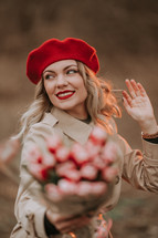 Young pretty woman in red beret, beige classic trench coat and bouquet of tulips. Girl on date. International Women's Day. Retro Parisian Style. High quality photo