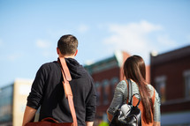 man and woman walking with bags outdoors 