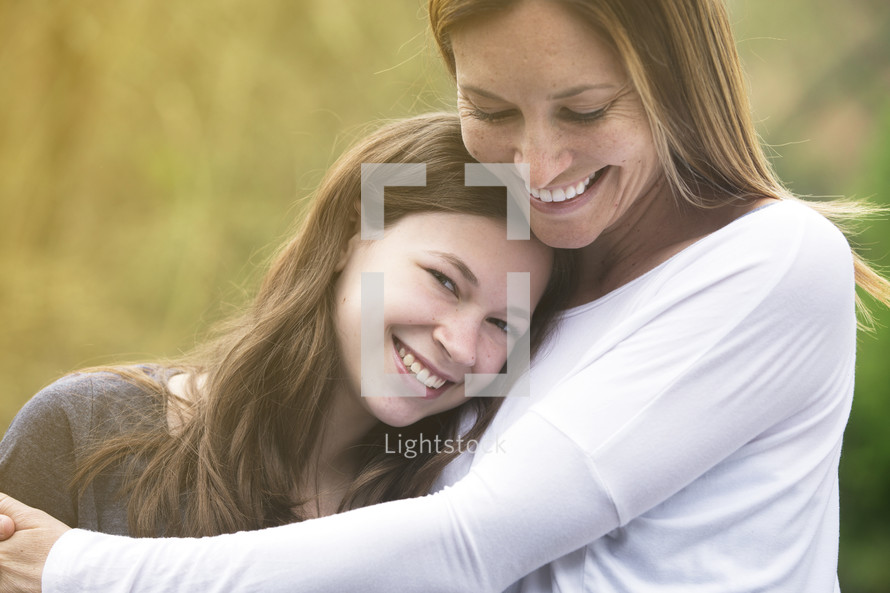 mother and teen daughter hugging 